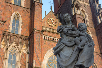 Obraz premium Siedemnastowieczna statua Matki Bożej z Dzieciątkiem na Ostrowie Tumskim we Wrocławiu na tle katedry