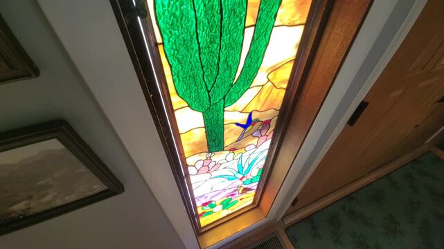 Intricate Stained Glass Featuring Agave And Cactus Motifs Illuminates Hallway With Colorful Patterns