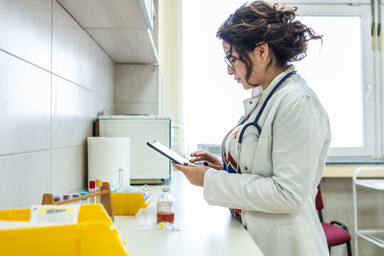 Doctor prepare vaccines in a treatment lab, working carefully with medical equipment. The scene feels sterile and focused, highlighting precision work.