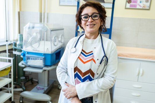 Pediatrician stand at her workplace, looking confident and professional. The portrait feels clean and modern, showing dedication to care.	
