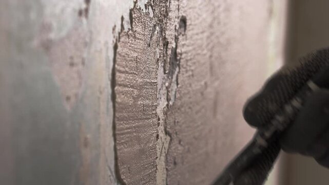 Worker hands applying wall putty with a spatula