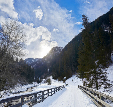 Beautiful winter hike over a bridge in the Hollersbach Valley, in the Salzburg region near Bramberg, Austria.