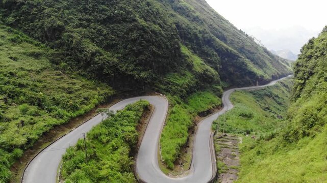 Aerial drone flight over winding mountain pass road &ndash; Ha Giang Loop, Vietnam