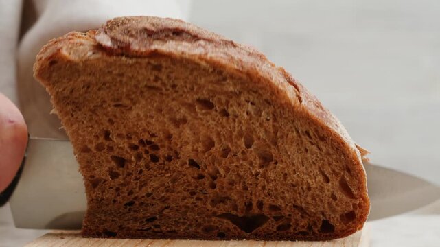 Black rye bread close up, dark brown sliced loaf, borodinsky slavic food, square slices with coriander on white background