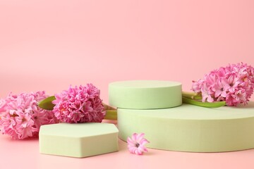 Empty podiums and spring flowers on pink background, closeup. Mockup for design