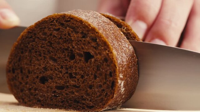 Black rye bread close up, dark brown sliced loaf, borodinsky slavic food, square slices with coriander on white background