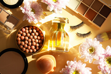Spring composition with different makeup products, perfume and pink chrysanthemum flowers on beige...