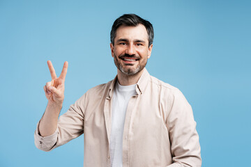 Happy man showing peace victory sign, feeling success and positive emotions