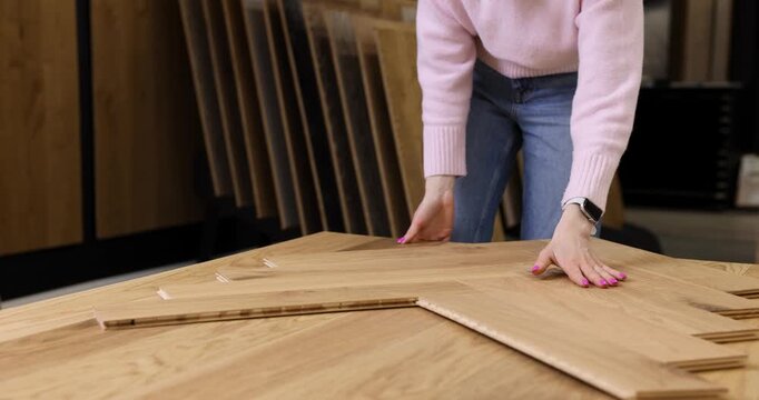 woman choosing parquet design in flooring shop