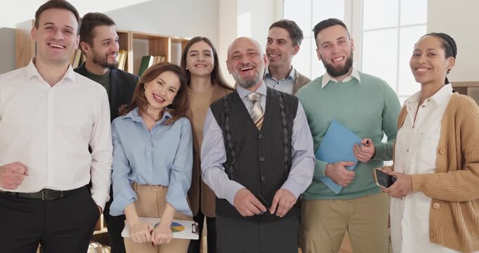 Teacher professor students group portrait education team. Smiling adults surround a trusted mentor in a classroom, celebrating guidance and support. Teamwork and academic success concept.