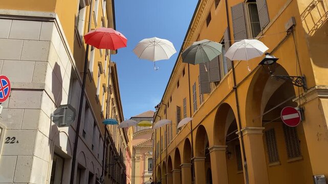 Street with Buildings and Colorful Umbrellas in Modena Italy on a Sunny Day