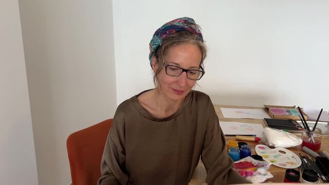 Push in rostro mujer satisfecha mirando su cuadro