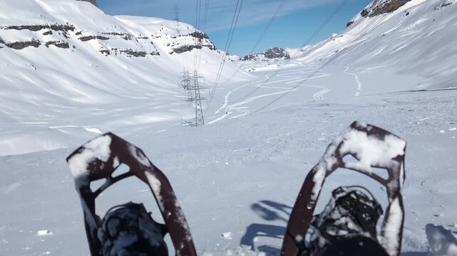 Person with snowshoes sitting at the top of the mountain in the winter