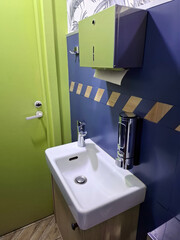 Fototapeta premium Restaurant restroom interior with sink, soap dish and paper