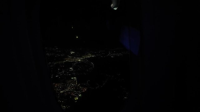 Aerial Night City Lights Seen from Airplane Windo