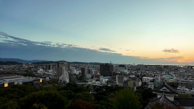 Panoramic Sunset View of Japanese City Skyline from Hilltop