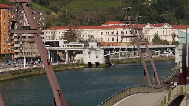 Sunny view of the Nervi&oacute;n River with the Deusto Bridge connecting the Deusto district and Plaza Euskadi in Bilbao Spain