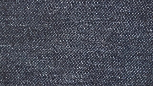 Dark blue denim fabric texture used as a simple background with copy space. Classic jeans textile surface ideal for fashion, apparel branding, and product presentation.