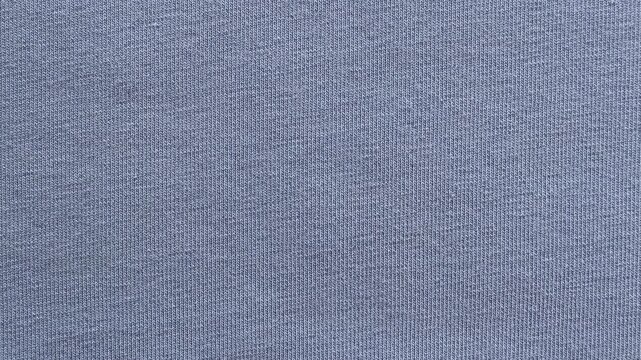 Soft blue knitted T-shirt fabric background with natural texture and copy space. Minimal textile backdrop ideal for fashion, apparel, design, and product presentation.