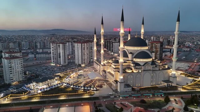 Aerial view captures hundreds of Muslims gathered at long tables for a communal Iftar meal at Ramadan.