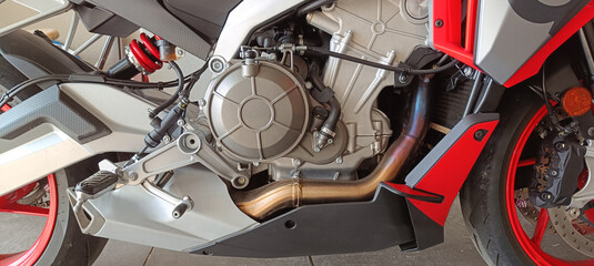 Close look at motorcycle engine and exhaust system showing mechanical design and construction details during daylight © Yaroslav