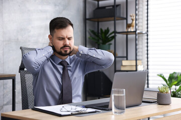 Man feeling fatigue at wooden desk in office