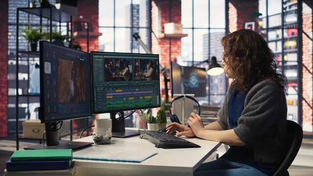 Filmmaker working on media post production from agency office, ensuring the editing timeline and color correction for a video shoot. Tech driven workspace showcases a digital workflow. Camera B.