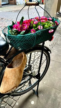 National tradition of the Netherlands, a basket of flowers on a bicycle with traditional Dutch wooden shoes - klompen on the street  