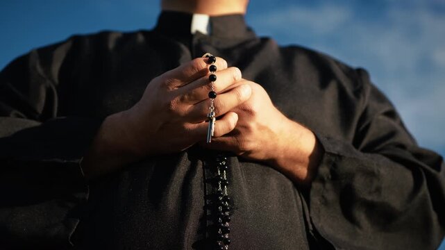 Hands Of A Priest Holding Jesus Crucifix While Praying 