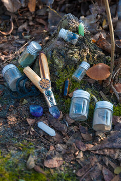 A traditional wooden kuripe pipe decorated with crystals alongside small glass vials of Rap&eacute; powder and healing stones. Shamanic tools. Spiritual plant medicine ceremony.