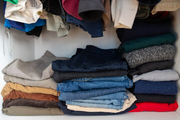 Organized wardrobe folded clothes jeans tidy home organization decluttering capsule wardrobe...
