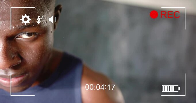 Male athlete holding steady pose in gym, REC starting and overlay timer counting highlighting sweat