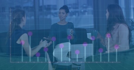 Gesturing woman in dark top, light pants holding cup in office lounge laptop phone data overlay