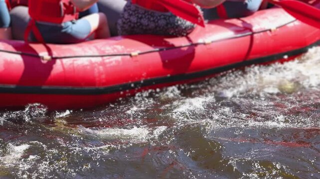 Rafting in whitewater, extreme water sports on water rapids, kayaking and canoeing tour in a mountain river,  water sports team, red and yellow raft boat full of tourists in a summer day, slow motion