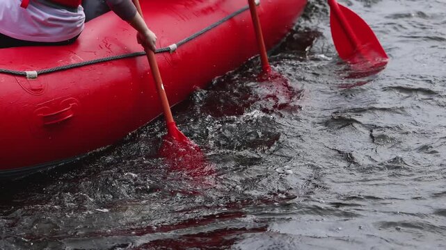 Rafting in whitewater, extreme water sports on water rapids, kayaking and canoeing tour in a mountain river,  water sports team, red and yellow raft boat full of tourists in a summer day, slow motion