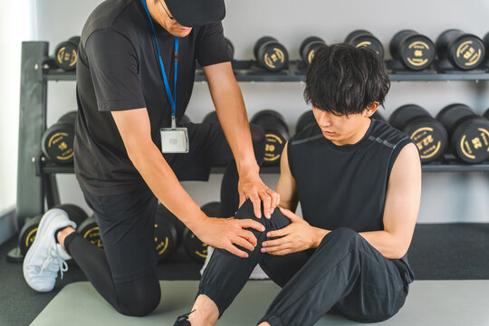 A man training with knee pain and a male sports physiotherapist