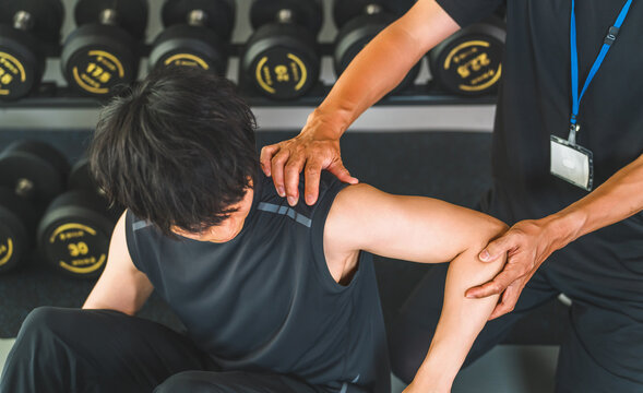 A man experiencing shoulder pain during training and a male sports physical therapist.