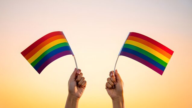 Colorful Pride Flags Held High Against a Vibrant Sunset Sky