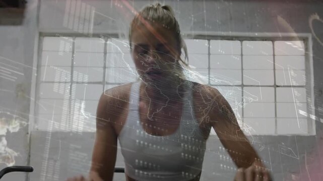 Woman in white sports bra pedaling stationary bike at gym with map overlay, wearing fitness watch