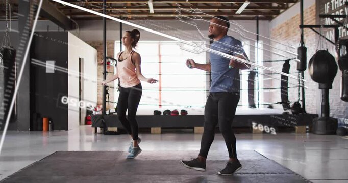 Two athletes holding ropes and starting swing, doing in sync cardio on mat, overlay tracking motion