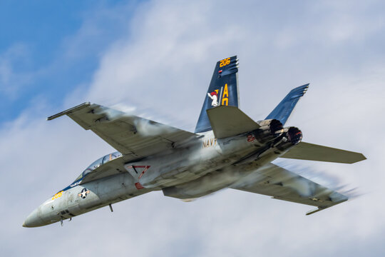 Boeing F-15 Eagle fighter jet banking in flight with vapor over wings