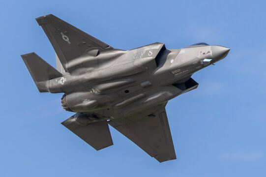 Lockheed Martin F-35 Lightning II stealth fighter jet banking in flight against blue sky