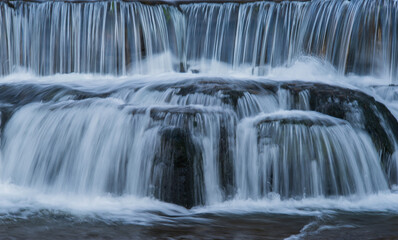 Obraz premium 段々のある滝を滑らかな水の流れが白い流れ模様として見られる風景