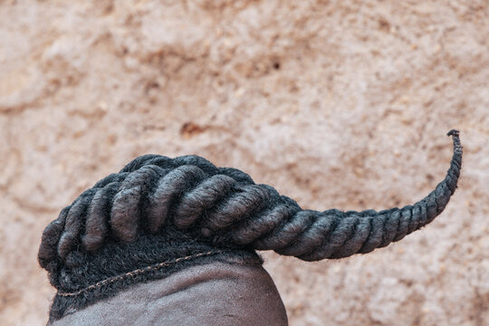 Close-up detail of Himba men's traditional hairstyle: shaved sides with an osibindi braid, Southern Angola