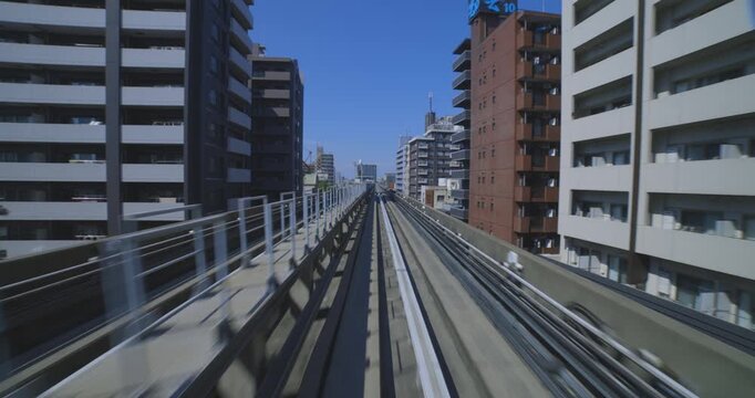 A hyper lapse of a moving backward urban monorail at the downtown in Tokyo by POV
