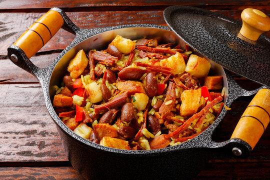 Bai&atilde;o de Dois served in a cast-iron pot with a wooden handle. Rustic regional Brazilian cuisine