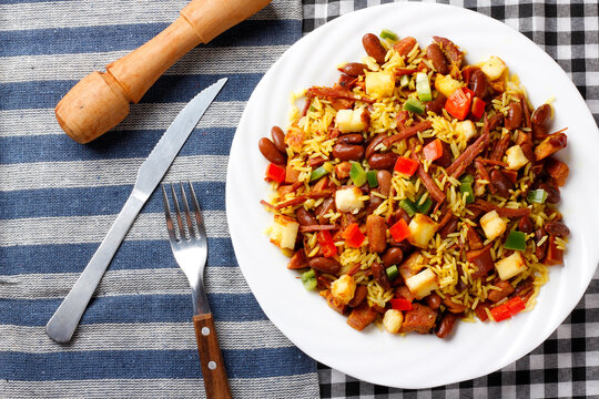 Bai&atilde;o de Dois served on a white plate with cutlery on a decorated table. Northeastern Brazilian cuisine and lifestyle