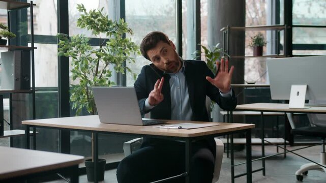 Busy Caucasian business man in office typing laptop talking mobile phone quarrel professional male manager multitasking discussing cellphone arguing client dissatisfied businessman guy writing notes