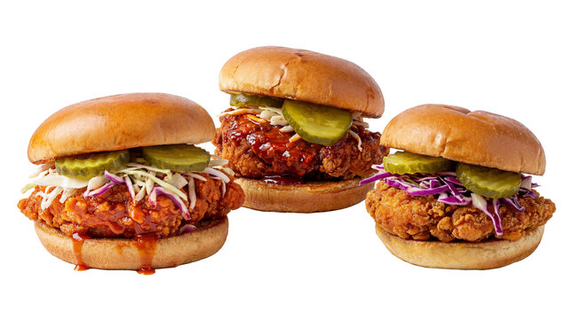 Three delicious crispy fried chicken sandwiches with pickles and coleslaw, isolated on transparent background.