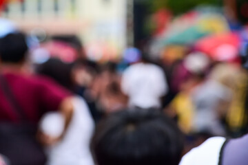 Fototapeta premium blurry photo of a crowd of people. Defocused street view with walking people at daytime. blur, blurred, bokeh. background, backgrounds. carnaval. peoples. festive scene. close up view